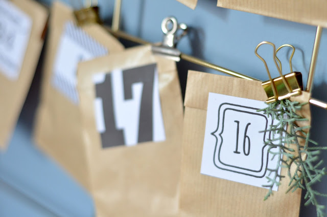 Calendario dell'Avvento fai da te con sacchetti di carta kraft, clip in metallo dorato e rametti di pino